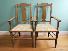 A pair of Arts and Crafts style oak armchairs, width 56 cm.