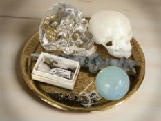 A small brass alms dish containing a dagger carved from moss agate, an opalescent orb,