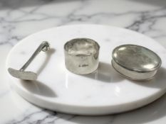A silver napkin ring, a circular lidded box, and a pusher CONDITION REPORT: 81.