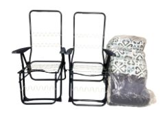 A pair of garden lounger chairs with cushions