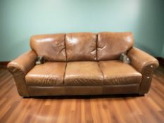 An Italsofa stitched chesnut brown leather three seater settee, with removable wooden feet,
