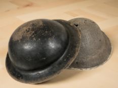 Two 20th century military tin helmets.