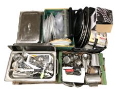 A group of stainless steel catering dishes, platters, assorted cutlery and utensils.