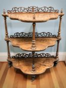 A Victorian figured walnut carved fret work three tier whatnot,