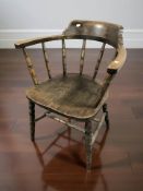 An early 20th century elm and beech spindle back elbow chair.
