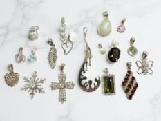 Several silver-mounted pendants including diamond, garnet, blue topaz,