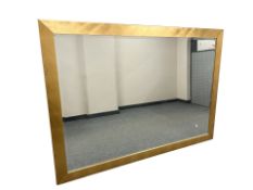 A large contemporary bevelled mirror in a gold coloured frame, 138 cm x 194 cm.