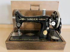 A Singer hand sewing machine in oak case.