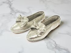 A pair of silver ballet shoes, length 9 cm.