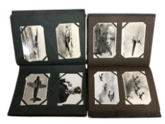 Two albums containing a large quantity of vintage and reproduction postcards and cigarette cards