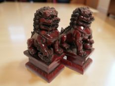 A pair of oriental resin temple dogs on plinths, height 18 cm.