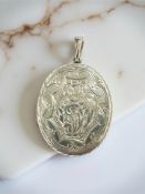 An oval silver locket with double sided engraved decoration CONDITION REPORT: 10g.
