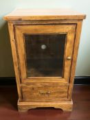 A Willis & Gambier oak entertainment cabinet, with glazed cupboard door and single drawer beneath,