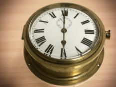 A brass ship's timepiece, diameter 20 cm.