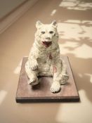 A cold painted metal figure of a seated bear on wooden plinth, height 12 cm.