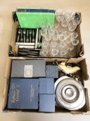 A group of crystal drinking glasses, community stainless steel cutlery,