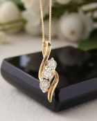 A 9ct gold three stone diamond pendant on chain