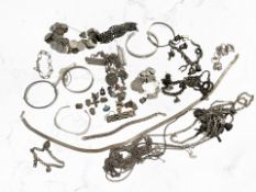 A collection of silver jewellery including charm and coin bracelets, ingot pendants, earrings,