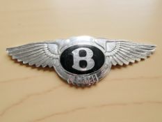 A chrome Bentley badge, width 15 cm.