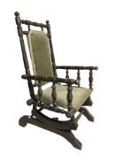 An antique child's rocking chair in green draylon.