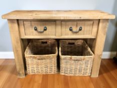 A modern solid pine two drawer butcher's block style side table with two wicker baskets beneath,