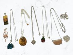 Several silver gem set pendants including diamond, amber,