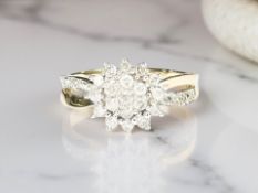 A 9ct yellow gold diamond cluster ring set with diamond shoulders, approximately 0.25ct, size K/L.