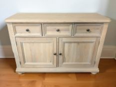 A modern pine sideboard, fitted three drawers and pair of cupboard doors beneath,