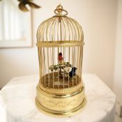 A Swiss bird cage automaton by Reuge Music, modelled as two song birds on a perch with foliage,