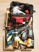 A group of power drills and saws with battery packs, hand tools, tool bag containing hardware.
