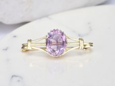A 9ct yellow gold bar brooch set with an amethyst,