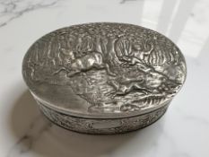 A silver oval lidded box with embossed hunting scene, 10 cm x 7 cm x 4 cm, London import marks 1894.