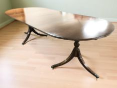 A reproduction mahogany twin pedestal extending dining table, with two leaves,