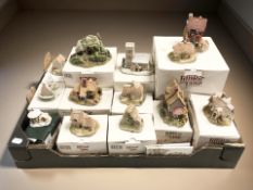 A group of Lilliput Lane cottages with boxes.