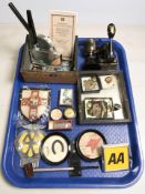 A group of AA badges, military badges, compass, magnifying glasses, desk punch, trophy cup, etc.