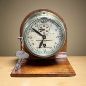 A brass circular timepiece signed 'Humphrey & Glasgow Limited, London', with key,