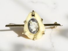 A Victorian yellow gold bar brooch set with a small shell carved in cameo, width 35 mm.