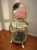 A brass and smoked glass two-tier circular trolley and a brass mirror
