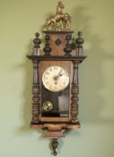 An early 20th century walnut wall clock with pendulum, height 80 cm.