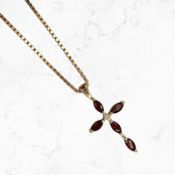A 9ct gold garnet and diamond crucifix pendant on 9ct gold chain CONDITION REPORT: 5.