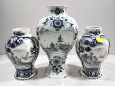 An 18th century Delft blue and white waisted baluster vase depicting a lady in a garden within a