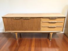 A G Plan teak low sideboard fitted three drawers and pair of cupboard doors,