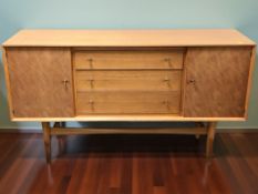 A Guy Rogers teak sideboard, fitted cupboard doors around three central drawers,