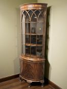 A reproduction mahogany bowfront standing corner cabinet,