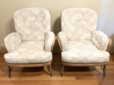A pair of Ercol elm and beech spindle back lounge armchairs, with floral cushions,