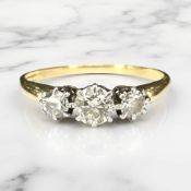 An 18ct gold and platinum three stone diamond ring, the principal stone approximately 0.