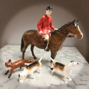 A Beswick huntsman on horseback, height 20.5 cm, two fox hounds and a fox.