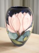 A Moorcroft Magnolia vase, height 17.5 cm, signed 'WM' to base.