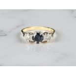 An 18ct yellow gold antique three stone diamond and sapphire ring, size K/L.