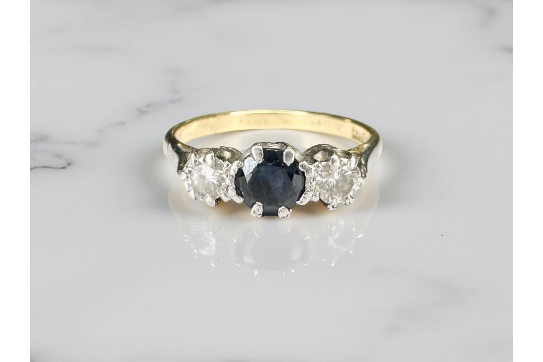 An 18ct yellow gold antique three stone diamond and sapphire ring, size K/L.